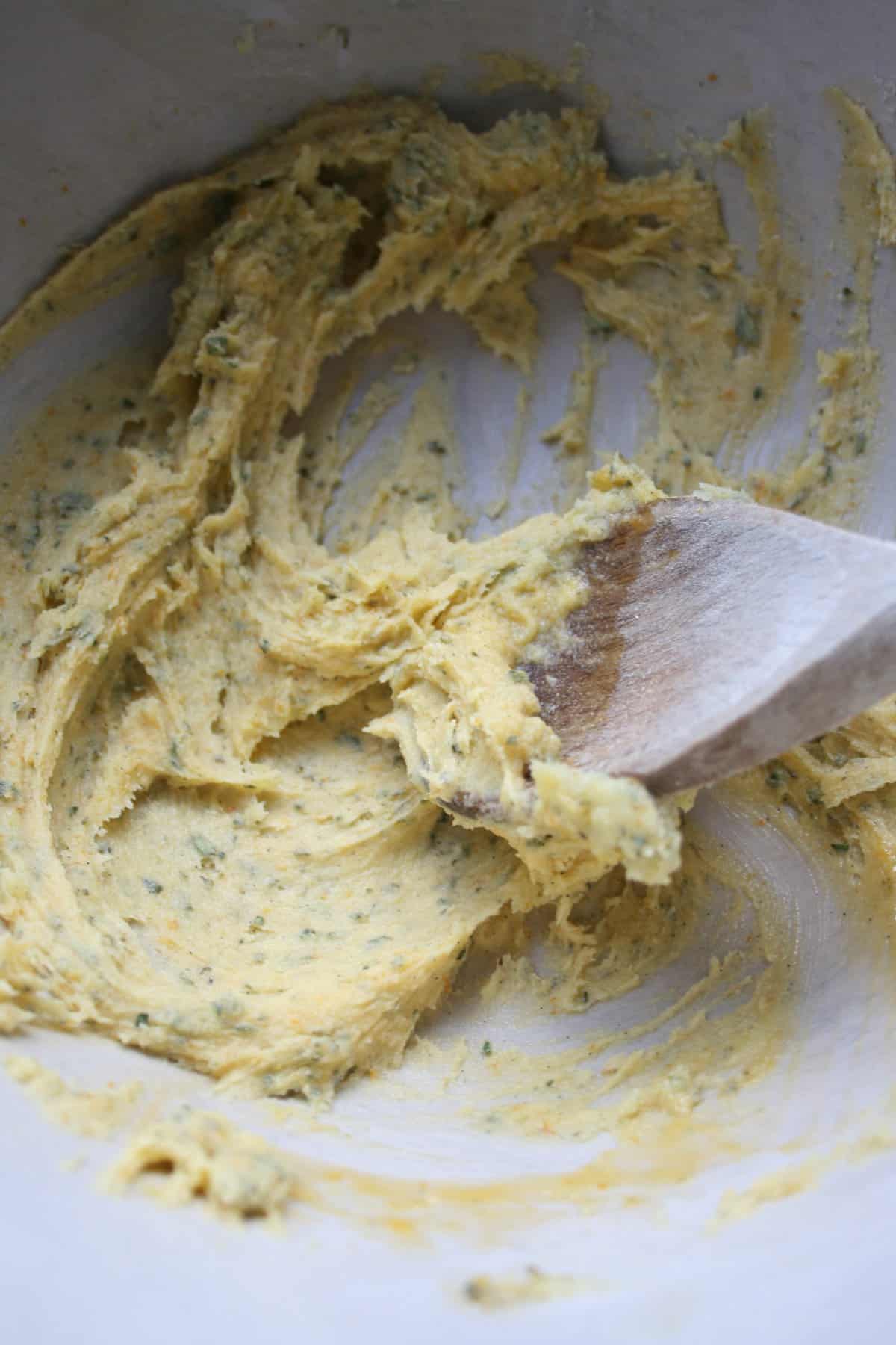 Biscuit dough in a bowl with a wooden spoon.