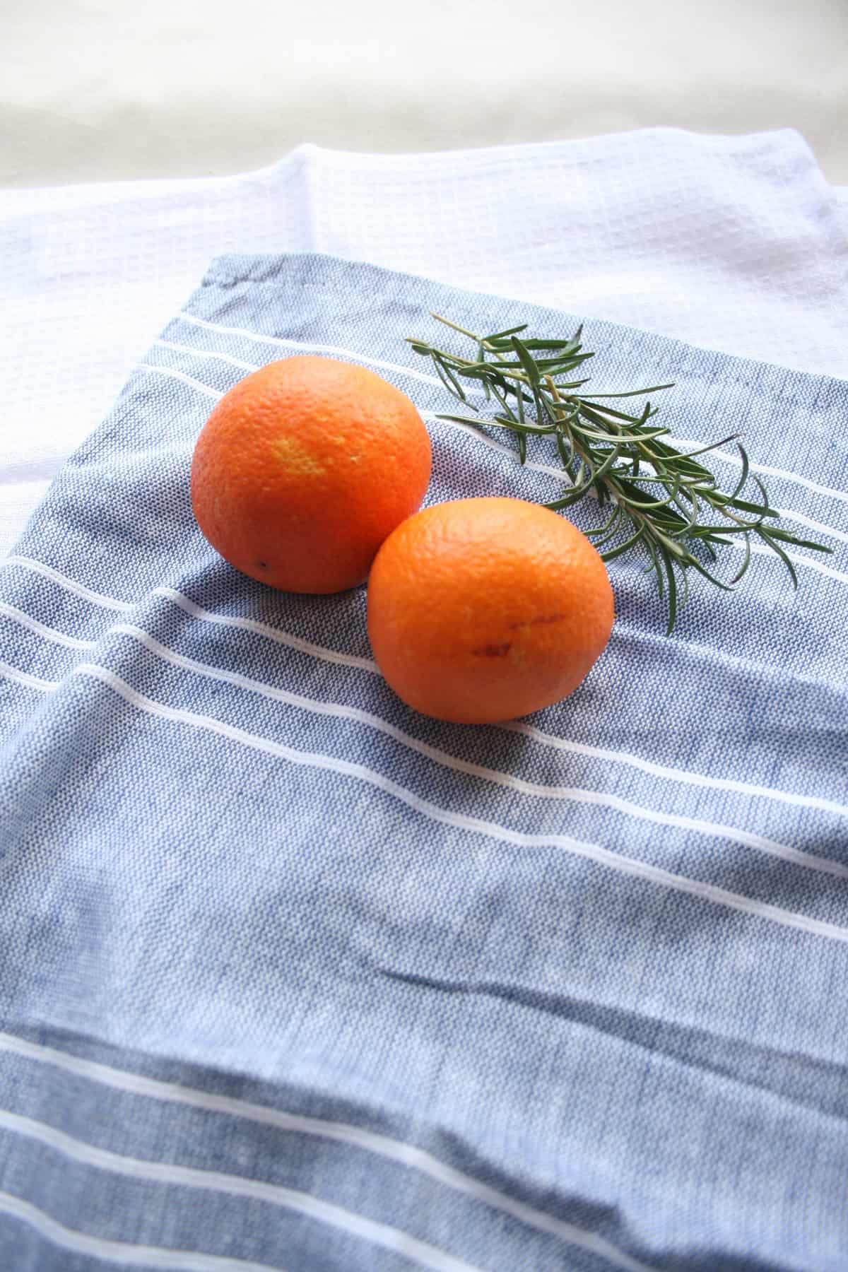 Oranges and rosemary on napkin. 