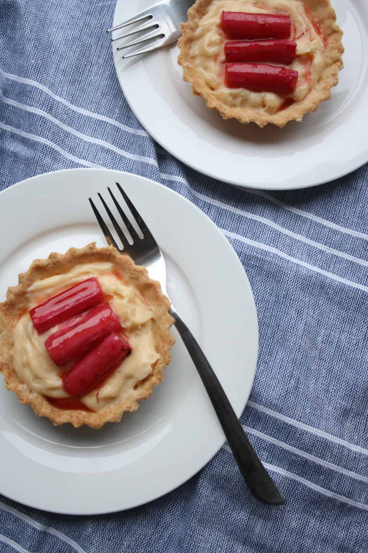 A plate with rhubarb custard tart with a fork.