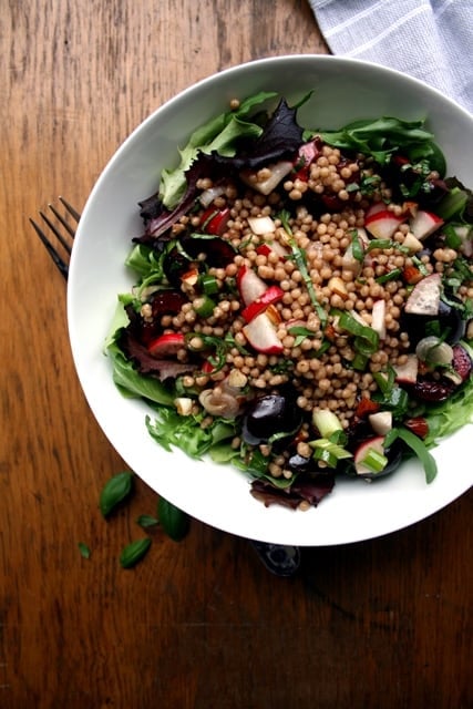 A bowl od cherry maftoul salad with a fork.