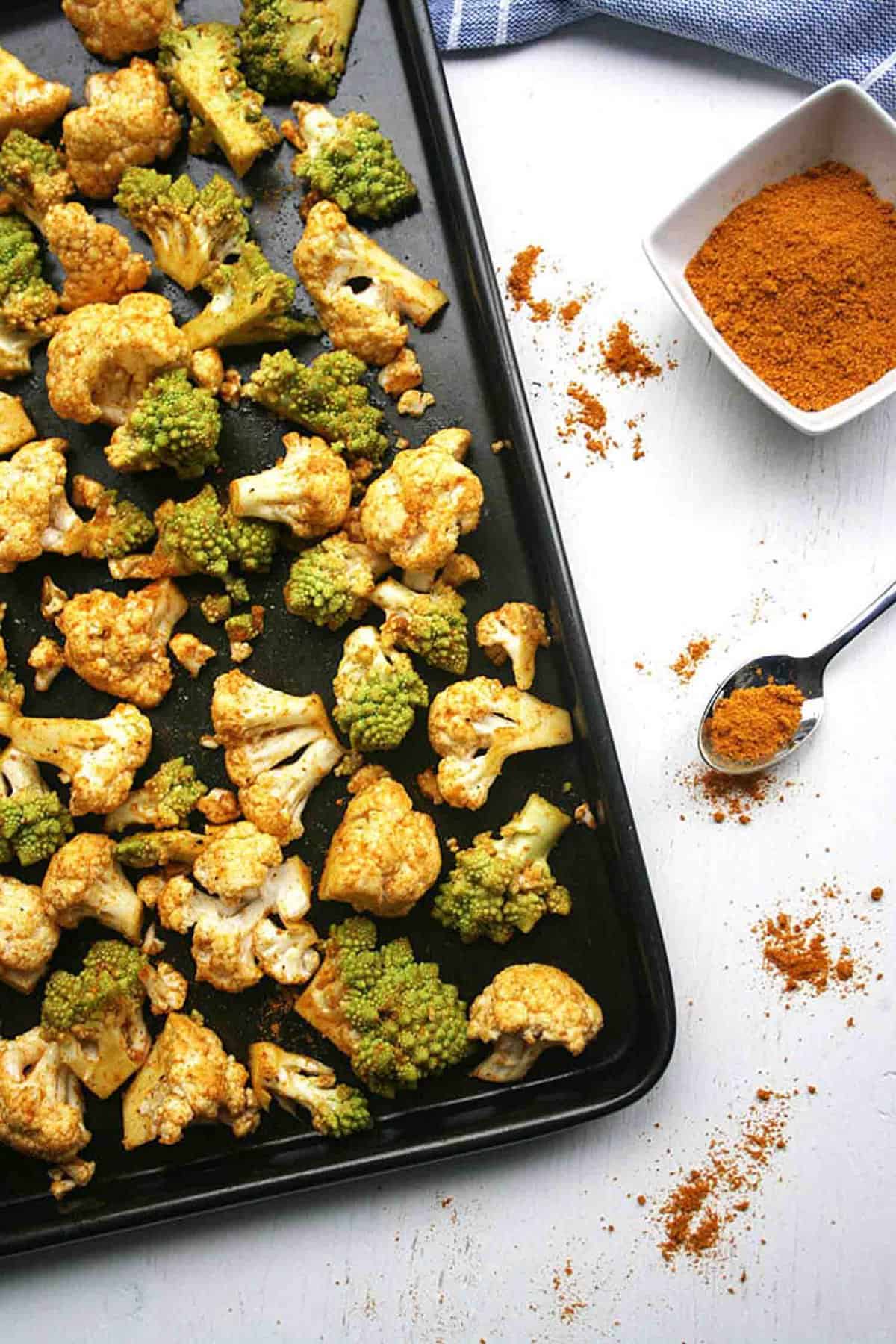 a tray of cauliflower chunks with spices to the side. 