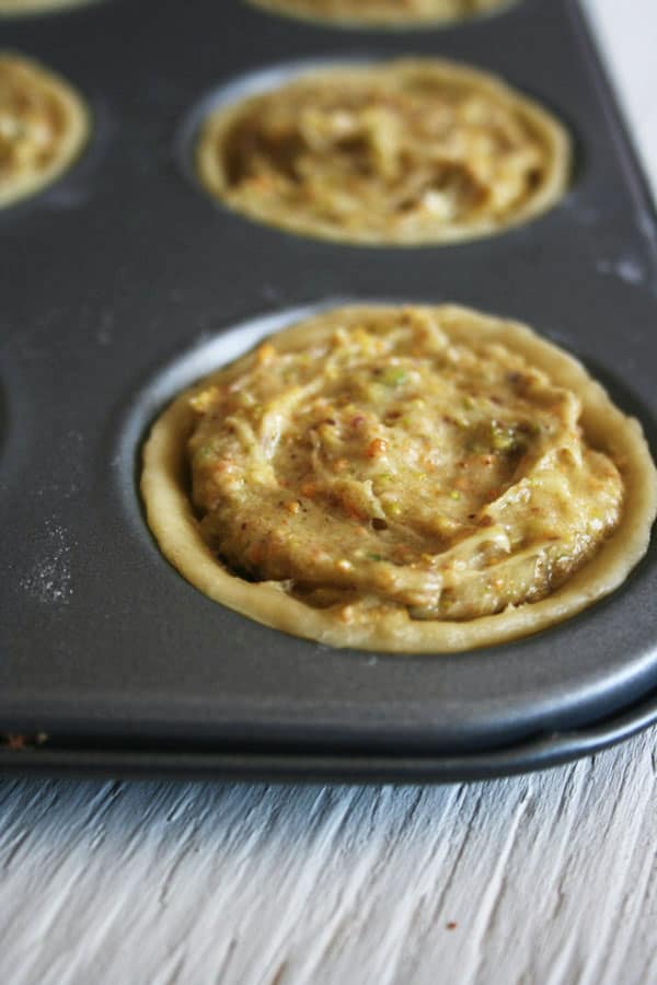 Close up of prebaked pastry with frangipane inside a baking tin.