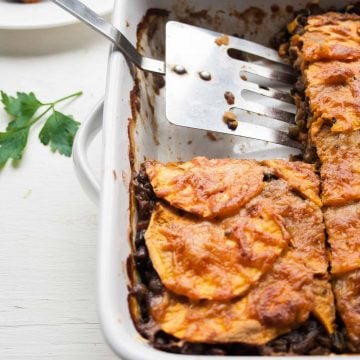 A spatula serving the sweet potato lentil lasagne from a dish.