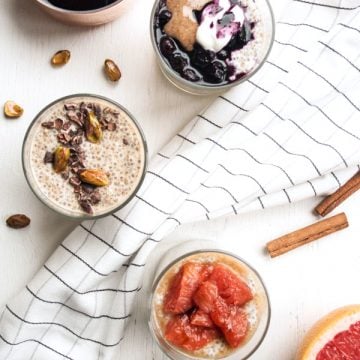 Three glasses with chia pudding and various toppings with a napkin running between.