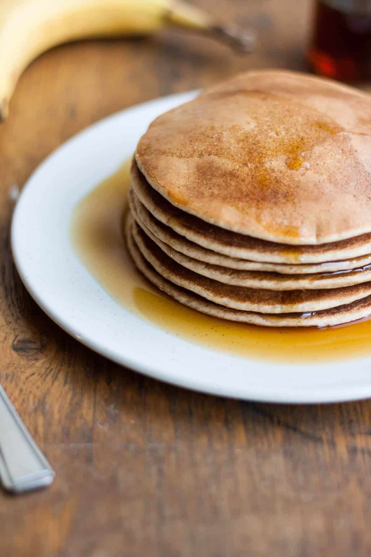 A stack of pancakes with maple syrup all over them.