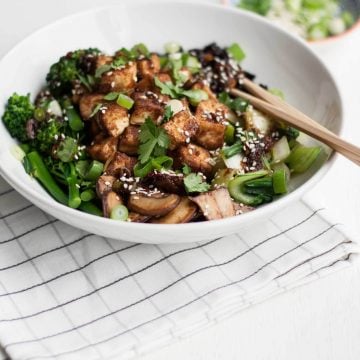 A bowl of crispy tofu with chopsticks on a napkin.