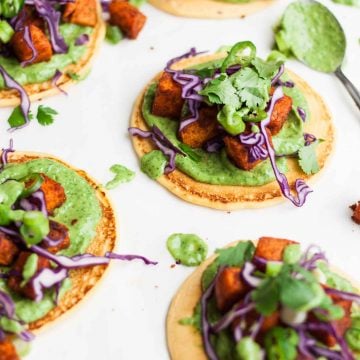 Vegan socca pizzas topped with sweet potato and cabbage.