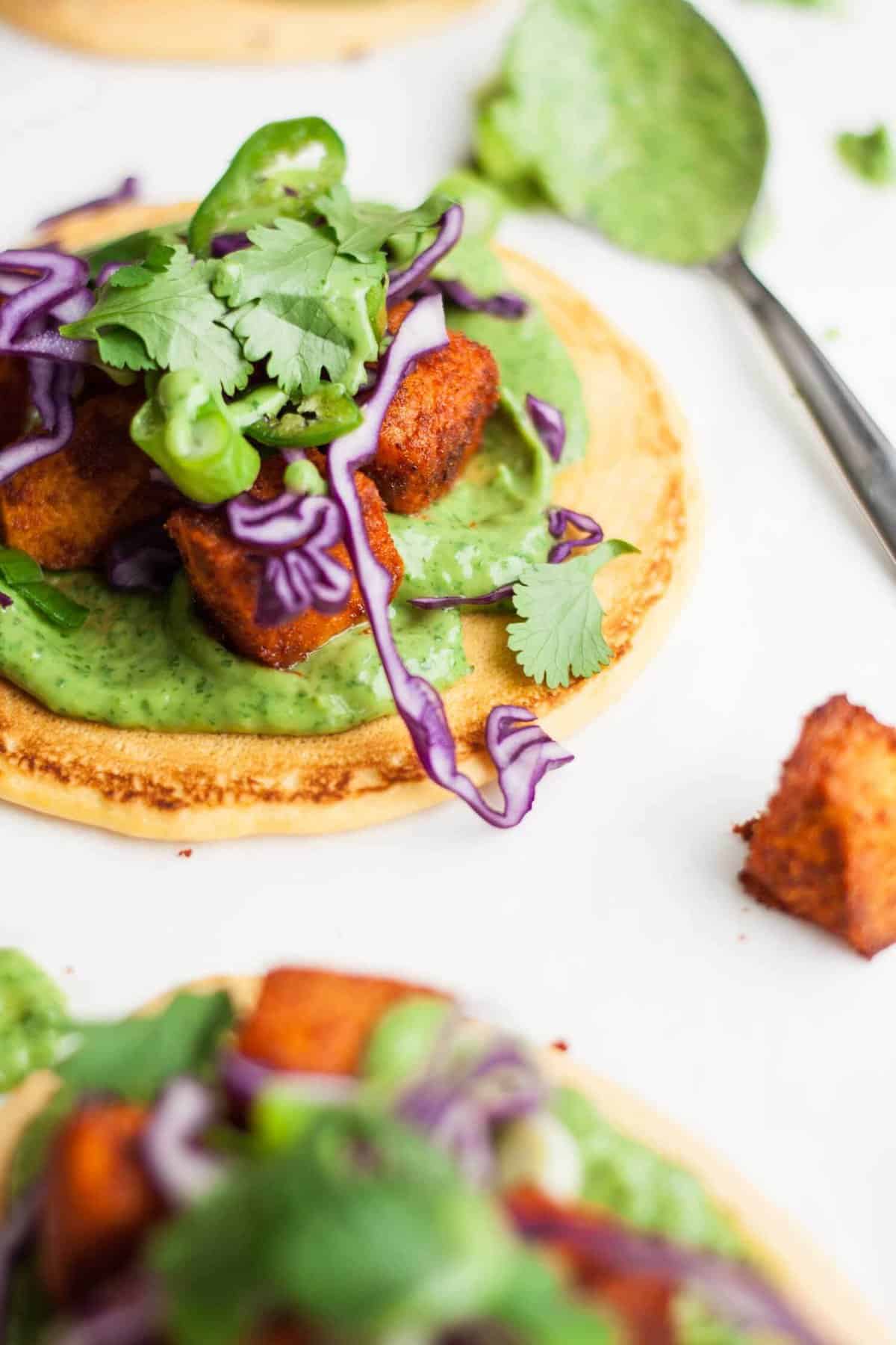 A socca pizza with sweet potato cabbage and avocado spread.