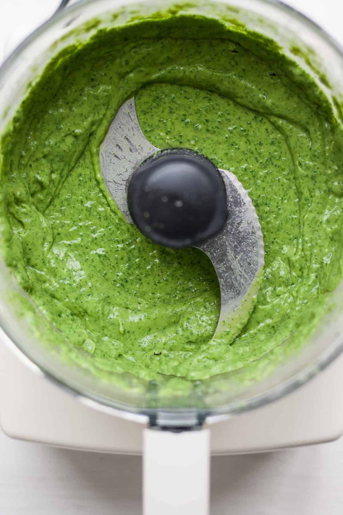 A food processor bowl with avocado cream blended up.