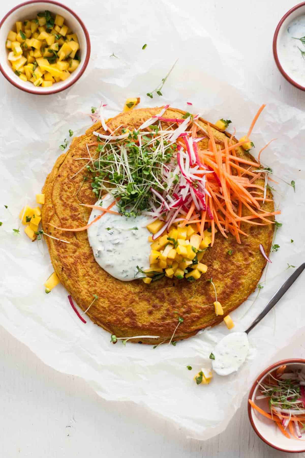 An onion bhaji pancake with salad toppings. 