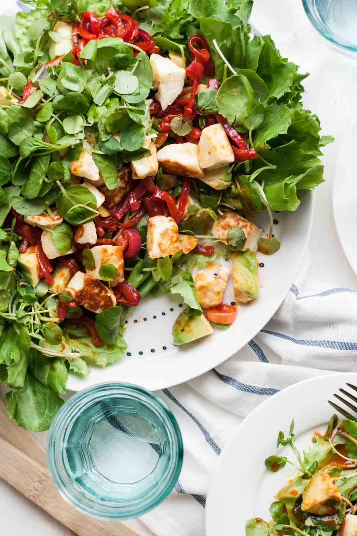 A halloumi salad partially served up from a platter.