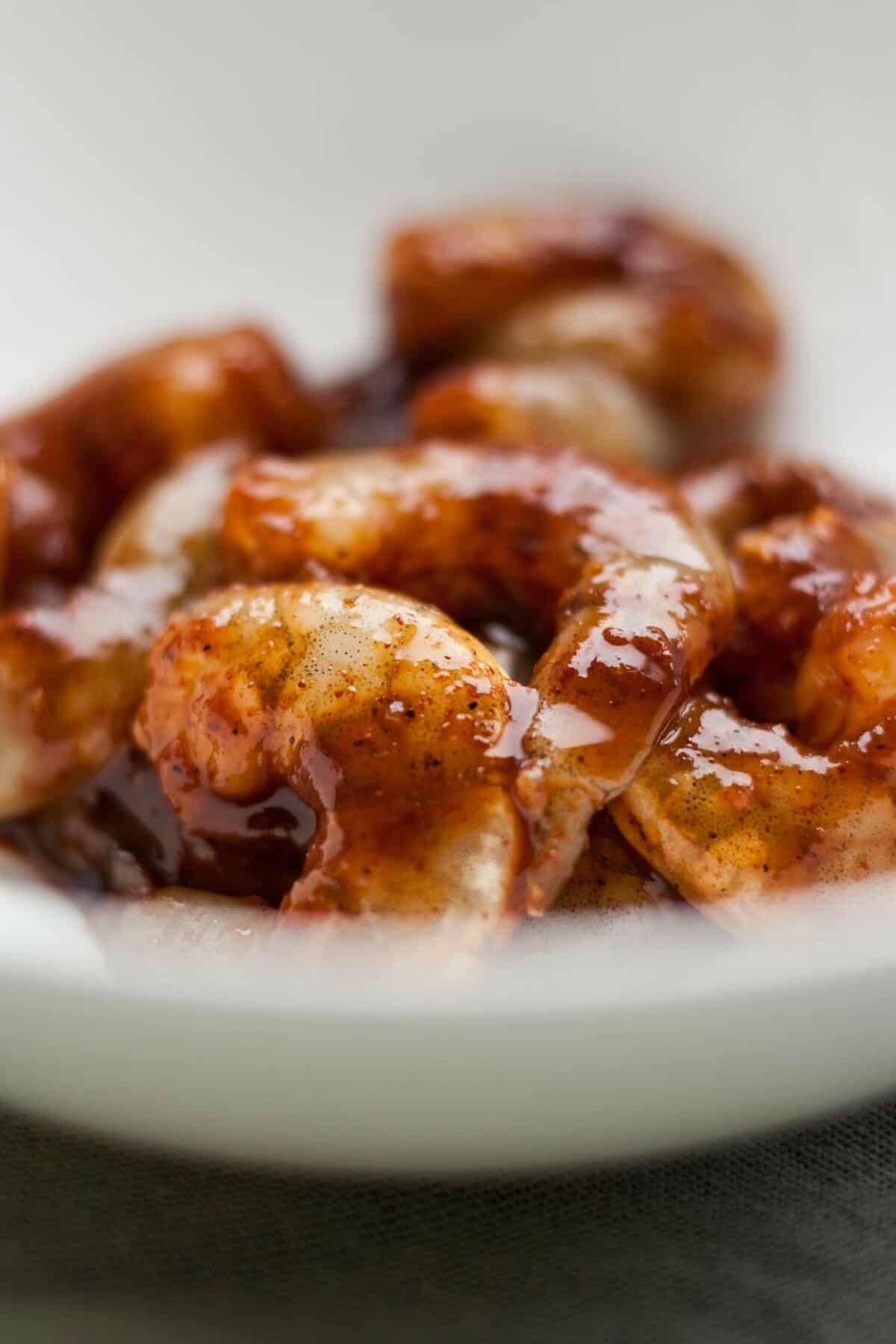 Prawns being marinated in a bowl.