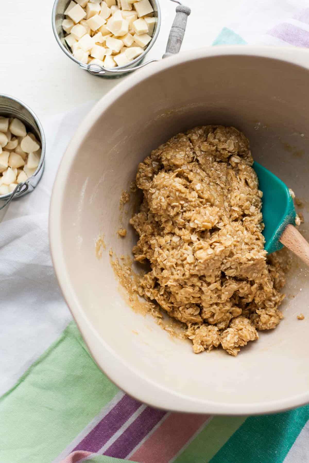 A bowl of oatmeal cookie dough with a spatula.