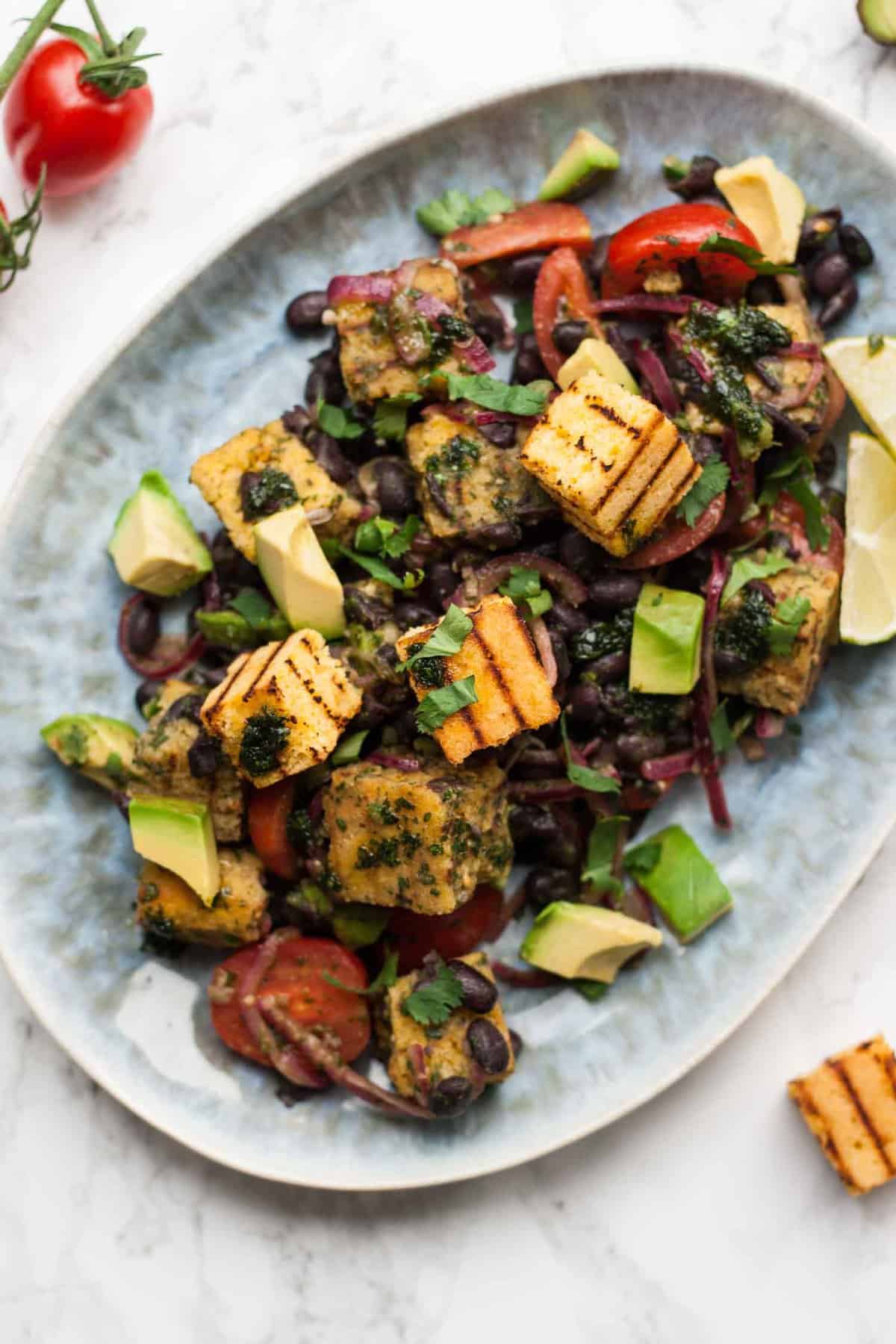 Close up of cornbread salad with beans and avocado on a plate