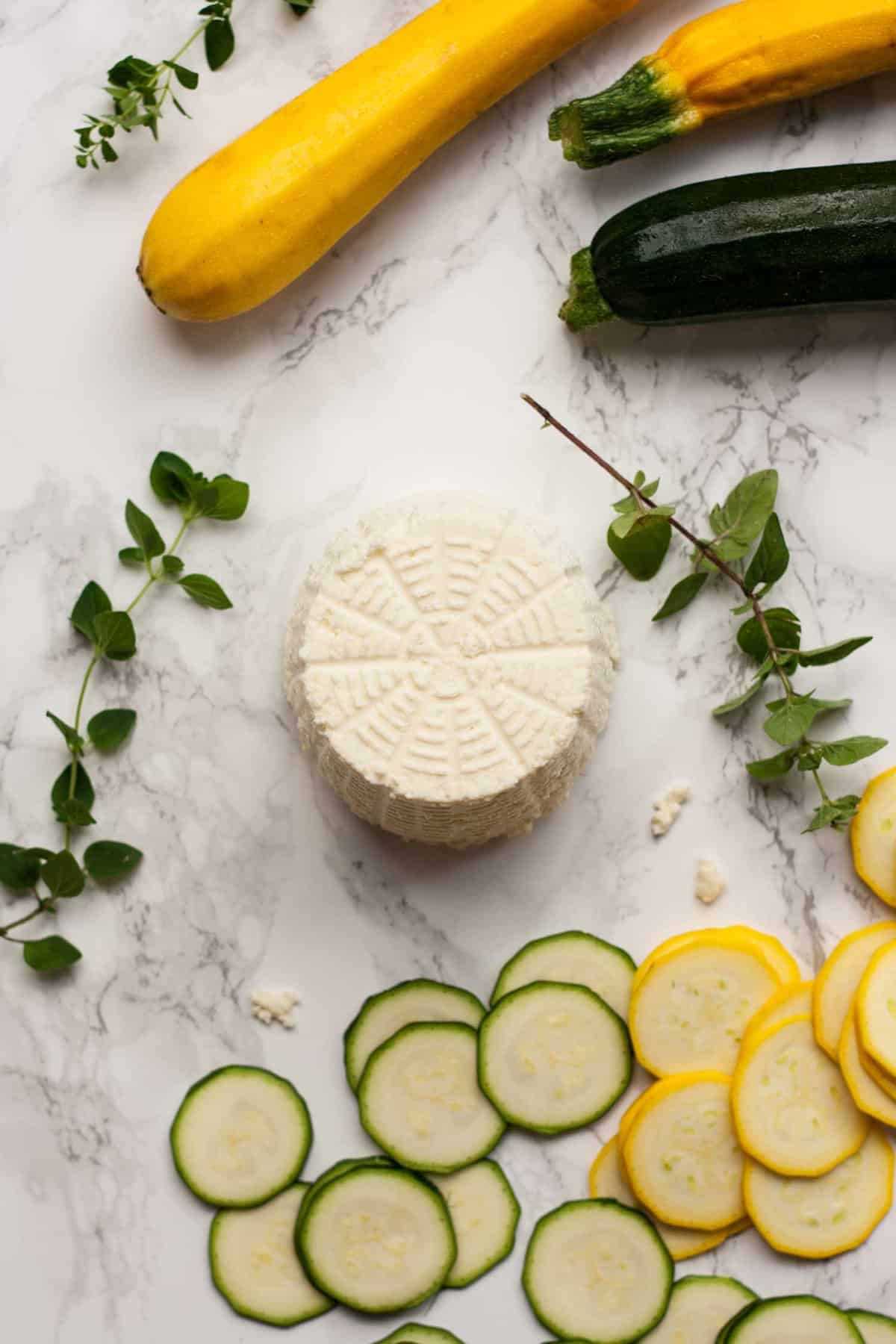Ricotta turned out from its mould with courgettes and zucchini slices around with fresh thyme.