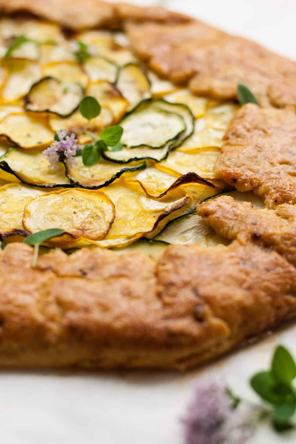Close up of golden pastry of the zucchini galette with fresh thyme on top.