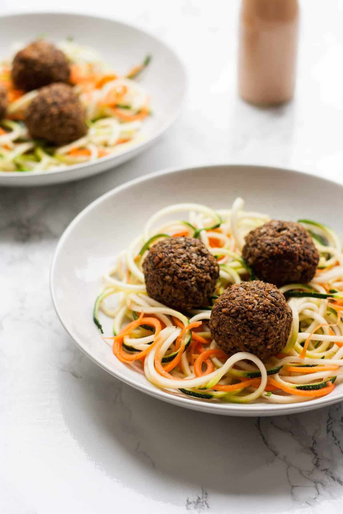 Vegan meatballs served on top of zoodles in a bowl.