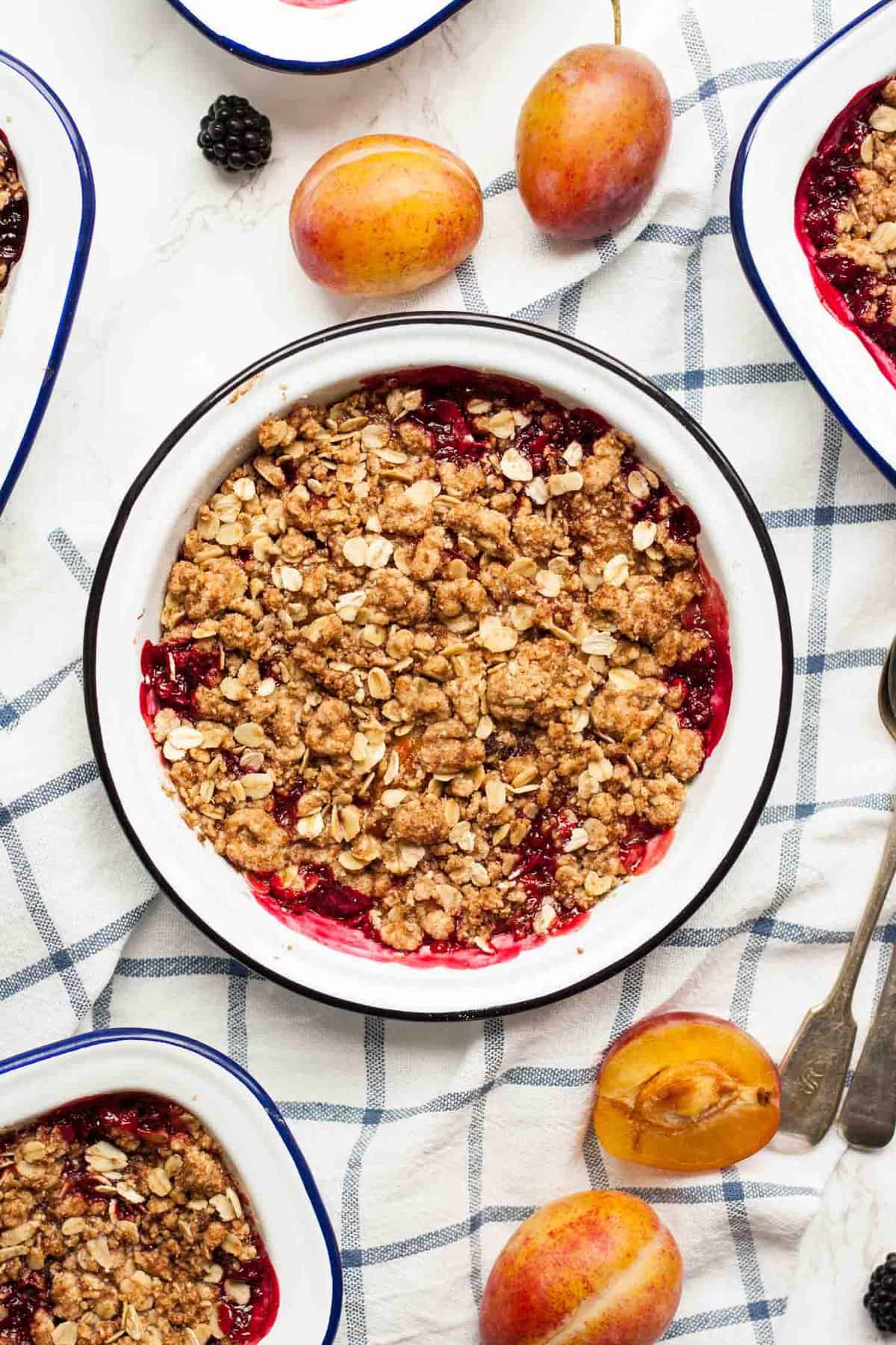 A baking dish with a baked plum and blackberry crisp.