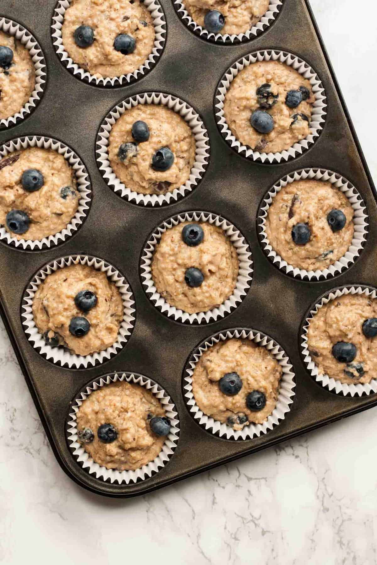 Pre baked blueberry muffins in a muffin tray