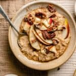 A bowl of maple brown sugar oatmeal with a spoon on a table cloth.