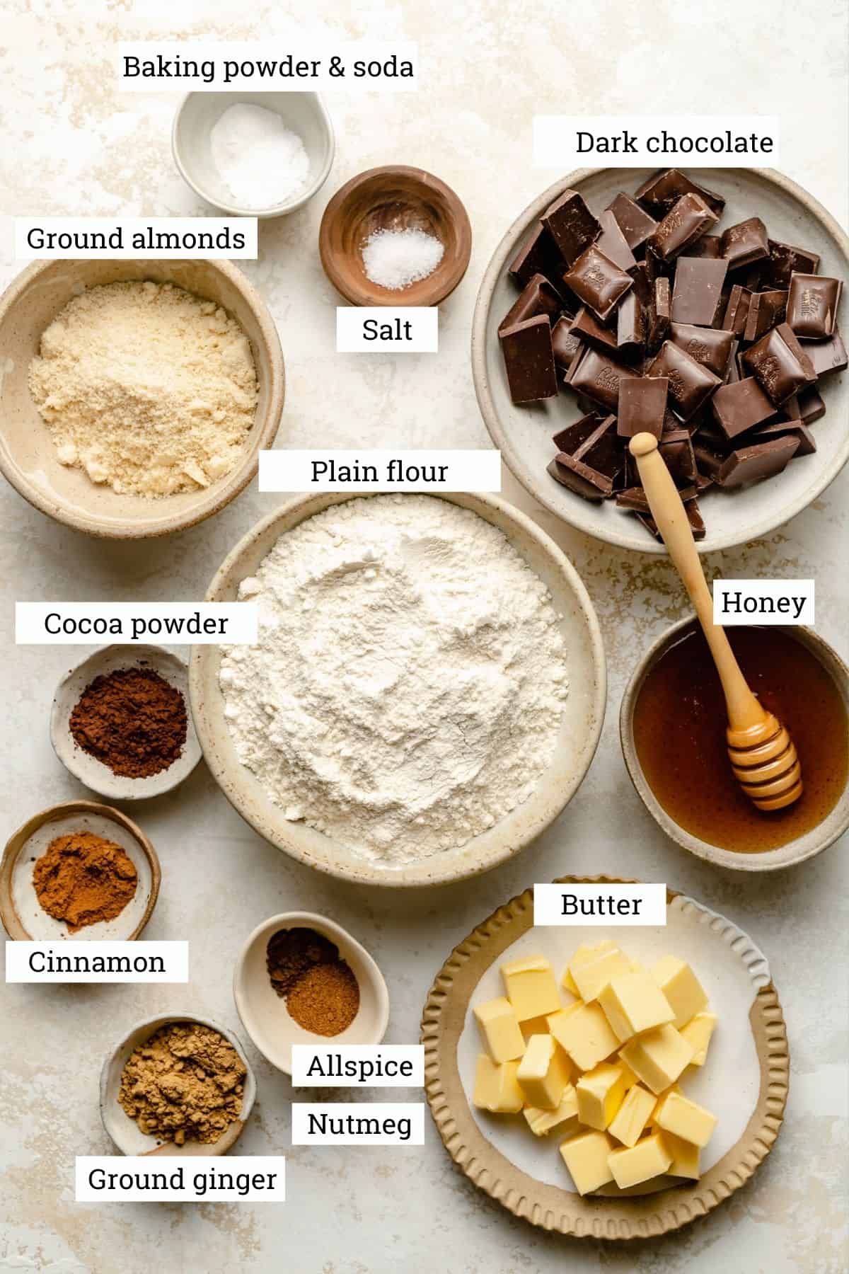 Ingredients for the lebkuchen cookies in various bowls with labels. 