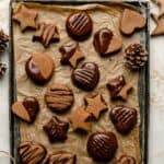 Chocolate lebkuchen arranged on a tray lined with parchment paper with string and decorations around.