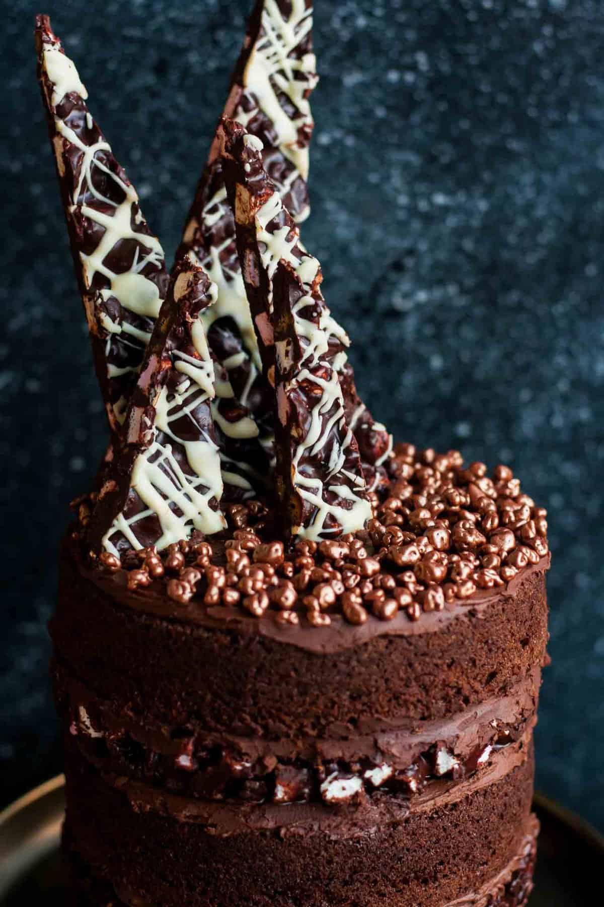 A close up of a chocolate rocky road shards on top of a cake.
