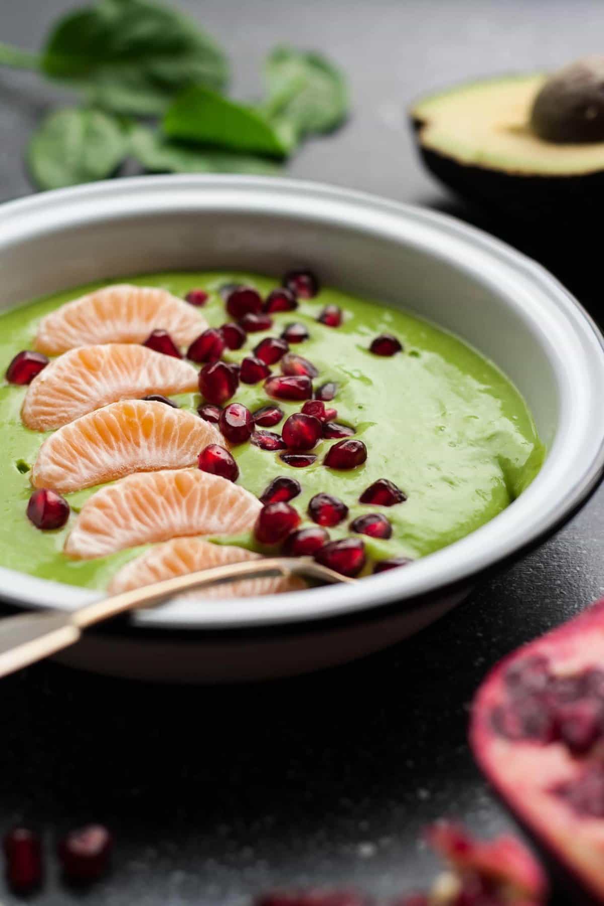 A close up side on shot of a spoon in a green smoothie bowl.