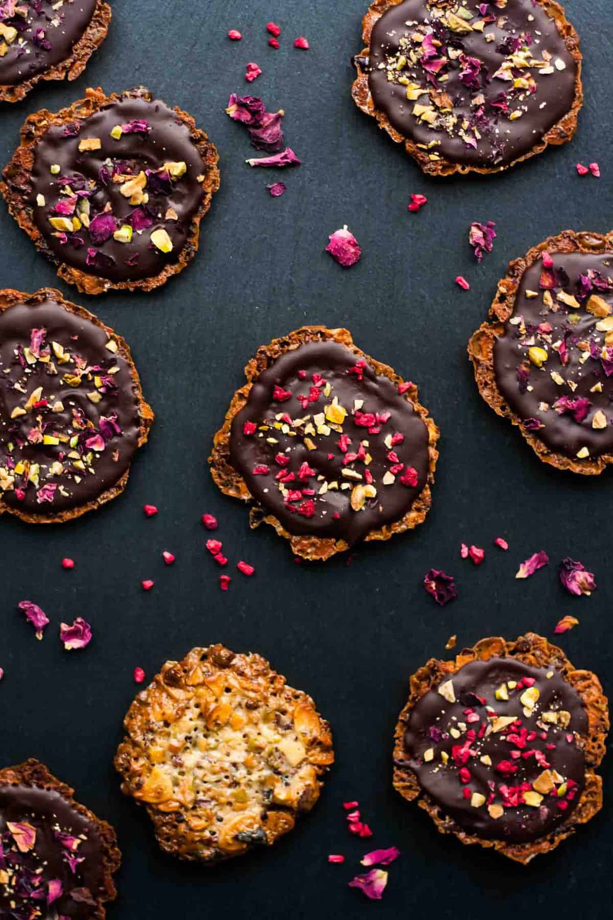 Chocolate almond florentines on a slate background.