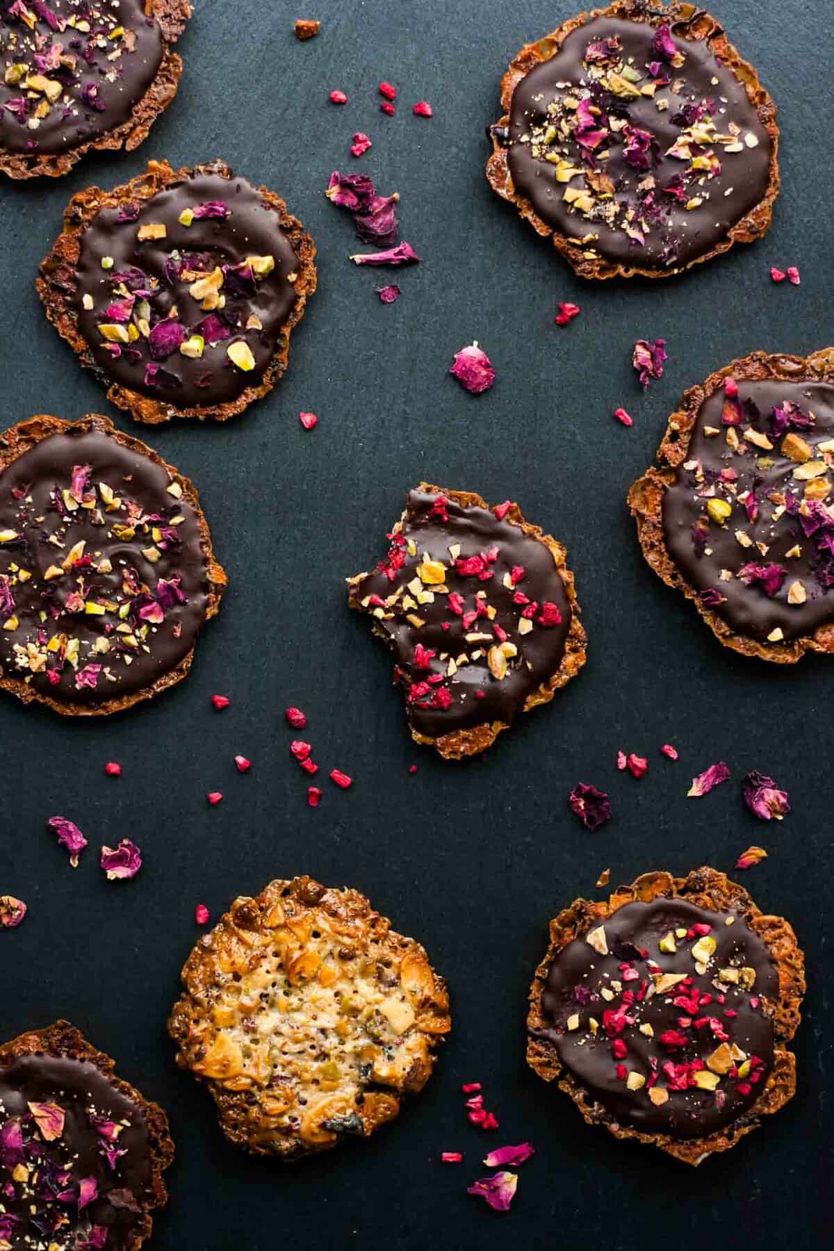 An array of almond florentines with one with bites taken from it.