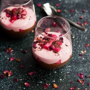 Two glasses containing a multilayered rhubarb and dark chocolate parfait with rhubarb on top.