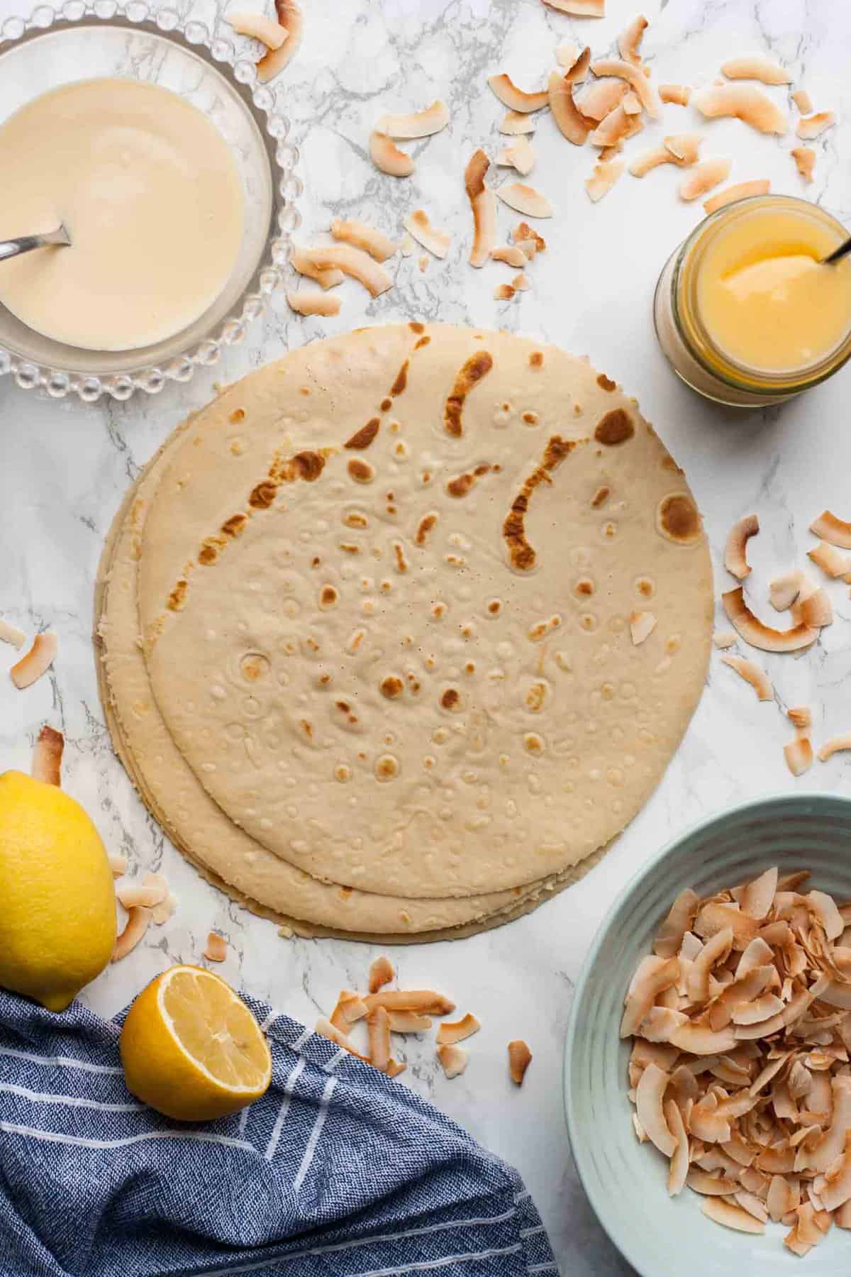 cooked crepes with lemon curd, toasted coconut and lemons.