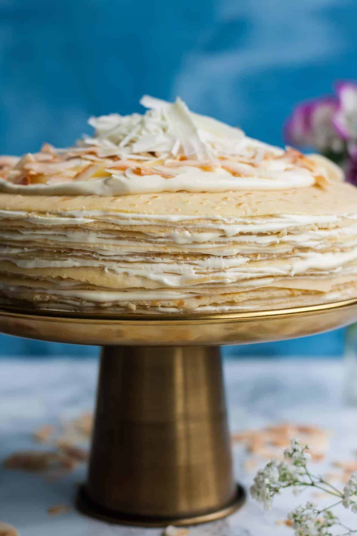 A close up of a crepe cake showing the layers with cream on top.