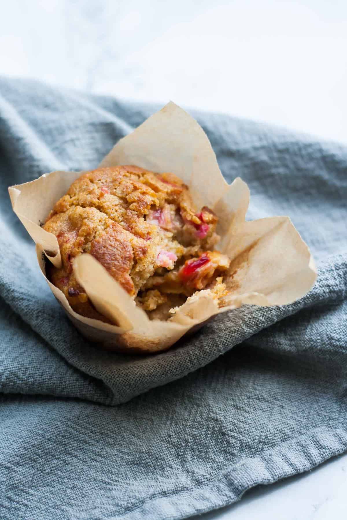 A muffin broken open on top of a napkin.