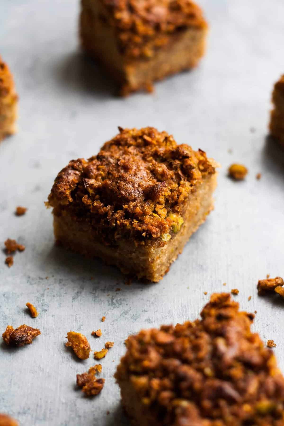 A square of rhubarb cake with crumbs around it. 