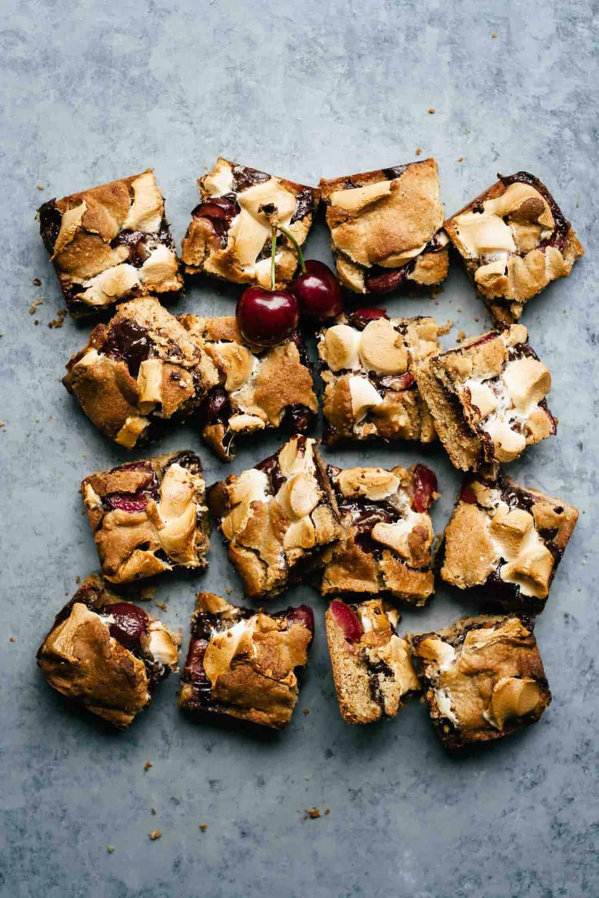 Cut up s\'mores bars with fresh cherries around.