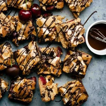 Chocolate cherry s'mores bars cut into squares with melted chocolate drizzled on top.