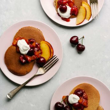 Almond Butter Pancakes on plates with fruit and yoghurt.