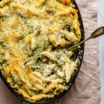 Creamy chicken pasta bake in a baking dish being served up with a spoon.