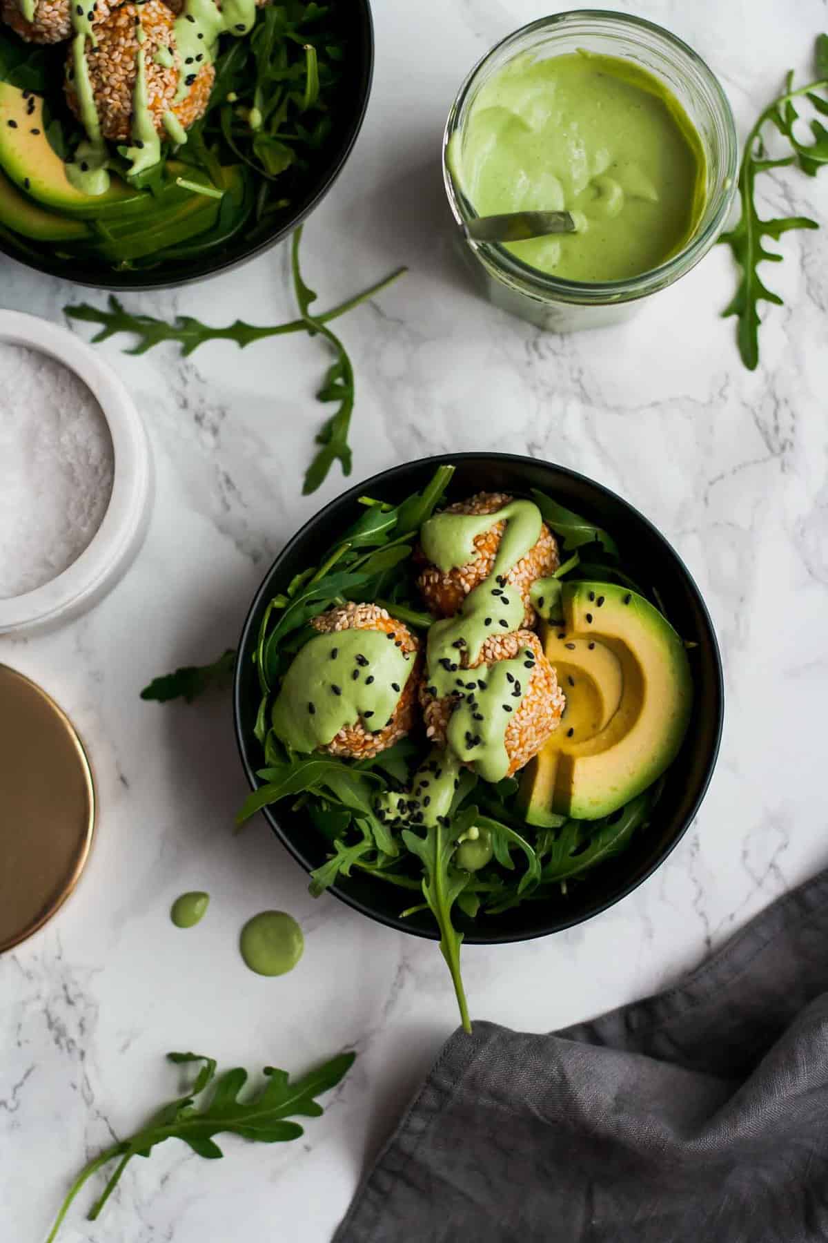 A bowl of sweet potato falafel with avocado and a sauce on top.