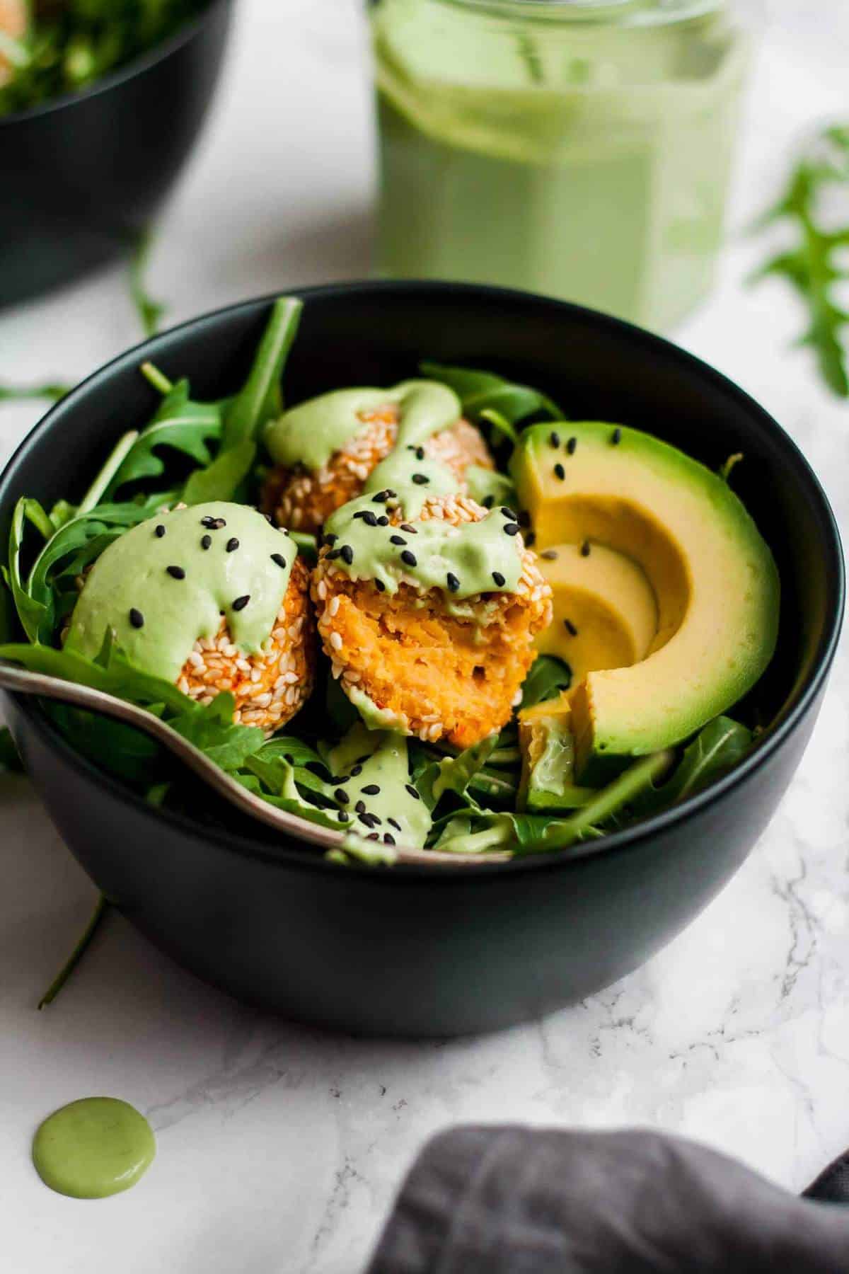 A broken open falafel in a bowl with a fork. 