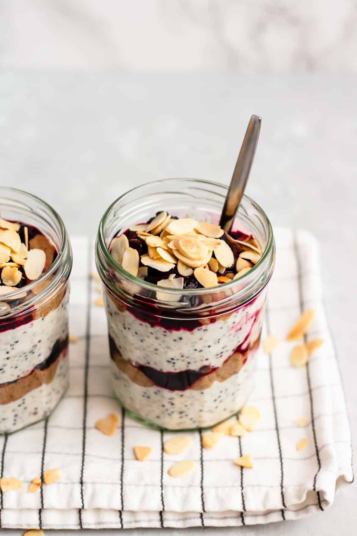 breakfast parfait with flaked almonds on top with a spoon.