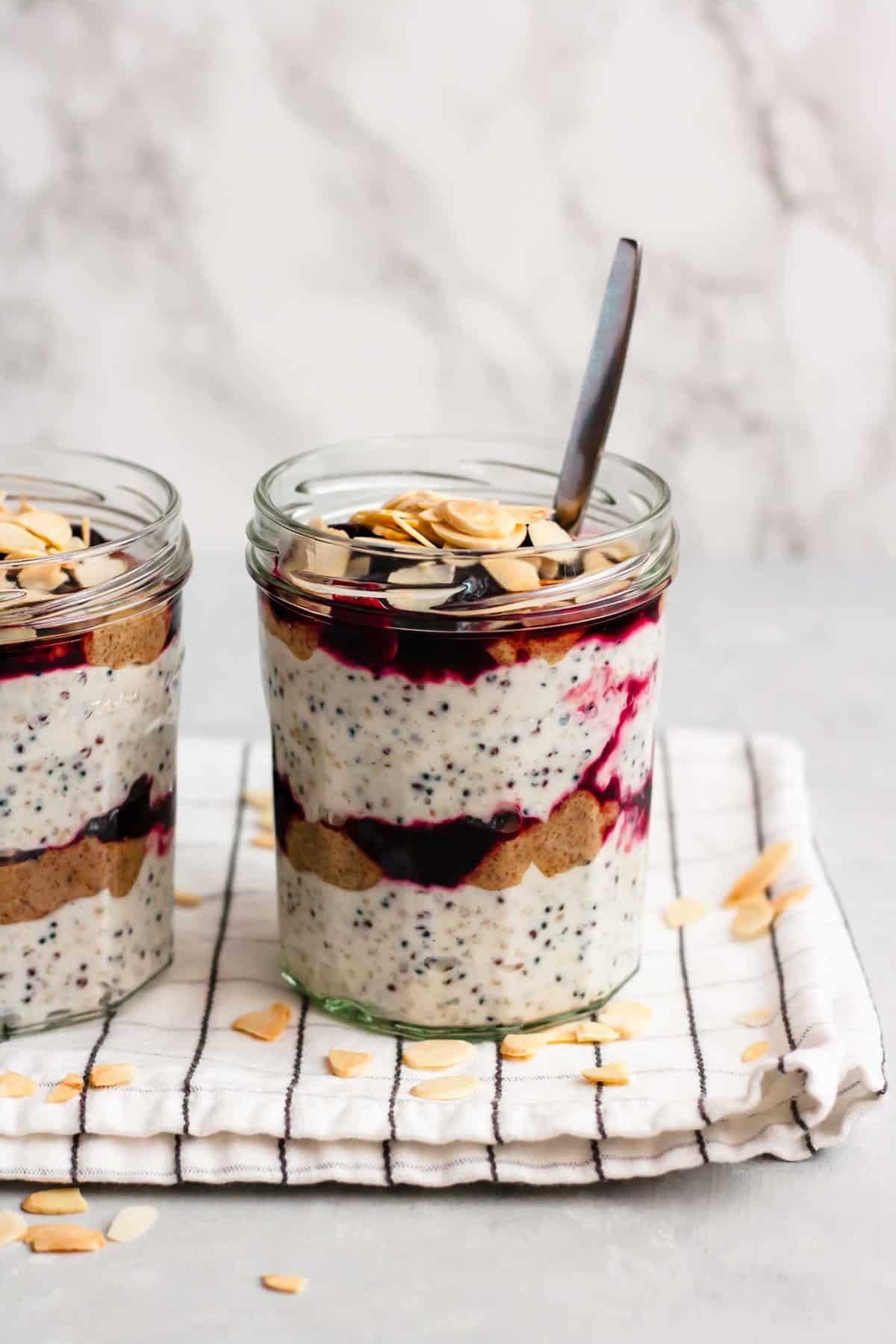 Cherry breakfast parfait in a jar with a spoon.