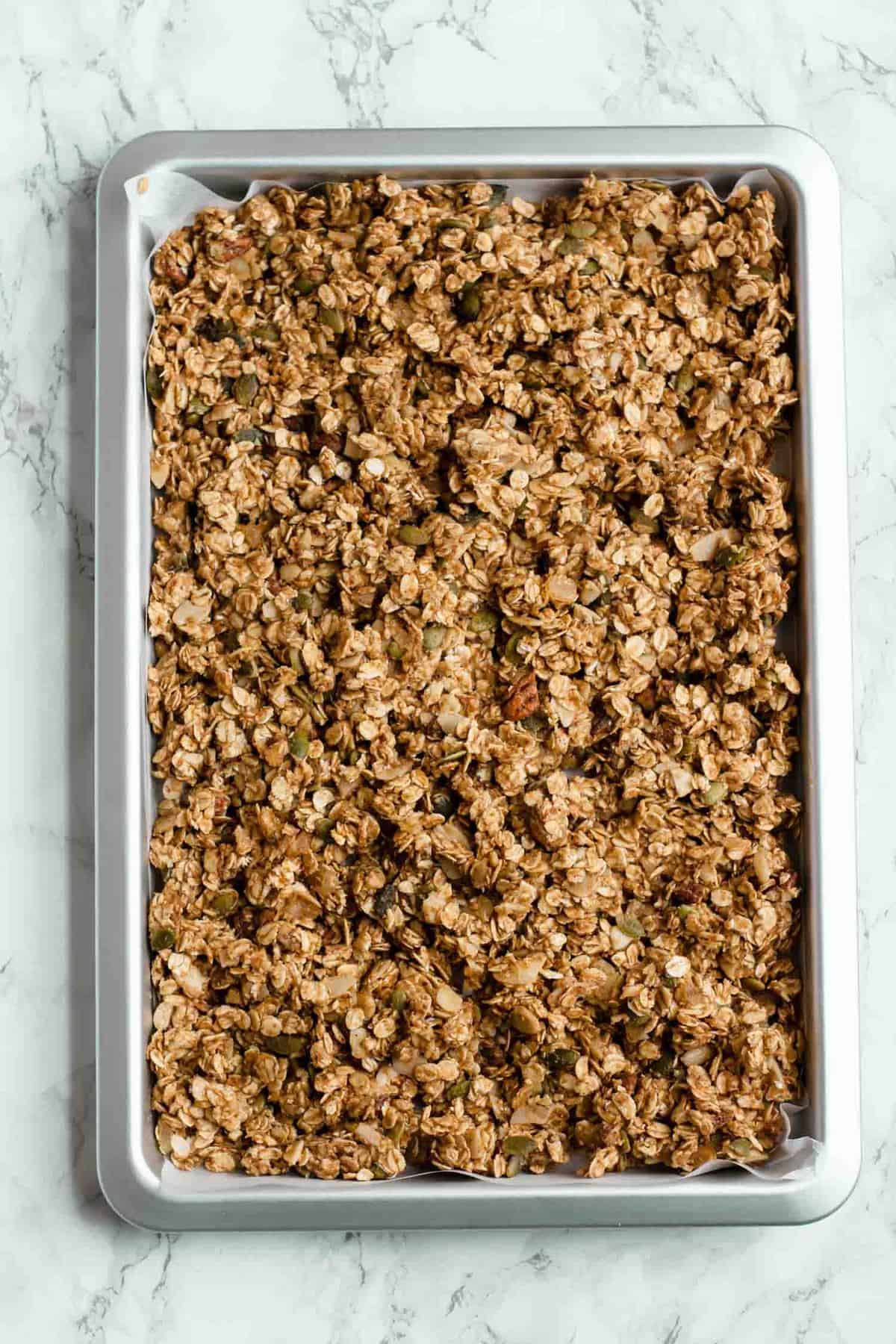 Pre baked granola on a baking sheet. 