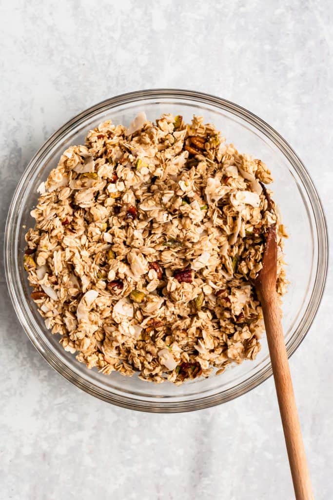 granola ingredients mixed together in a bowl with a spoon