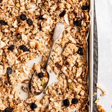 baking sheet with coconut tahini pistachio granola and a spoon