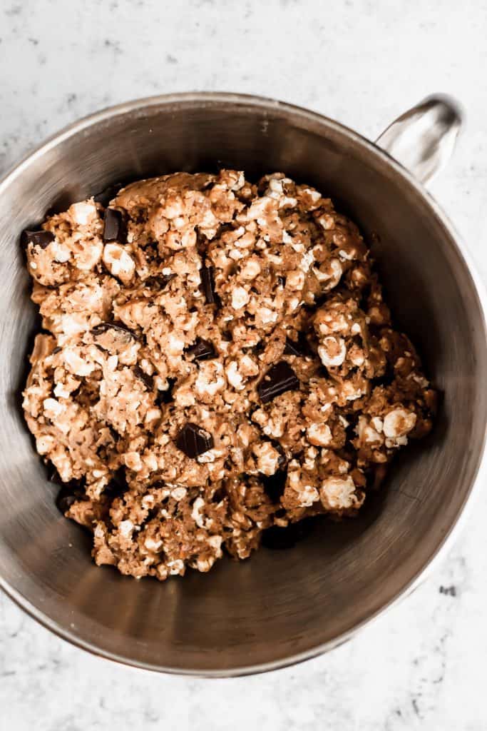 a stainless steel mixing bowl full of popcorn chocolate chip cookie dough