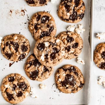 a tray of popcorn chocolate chip cookies with popcorn scattered around