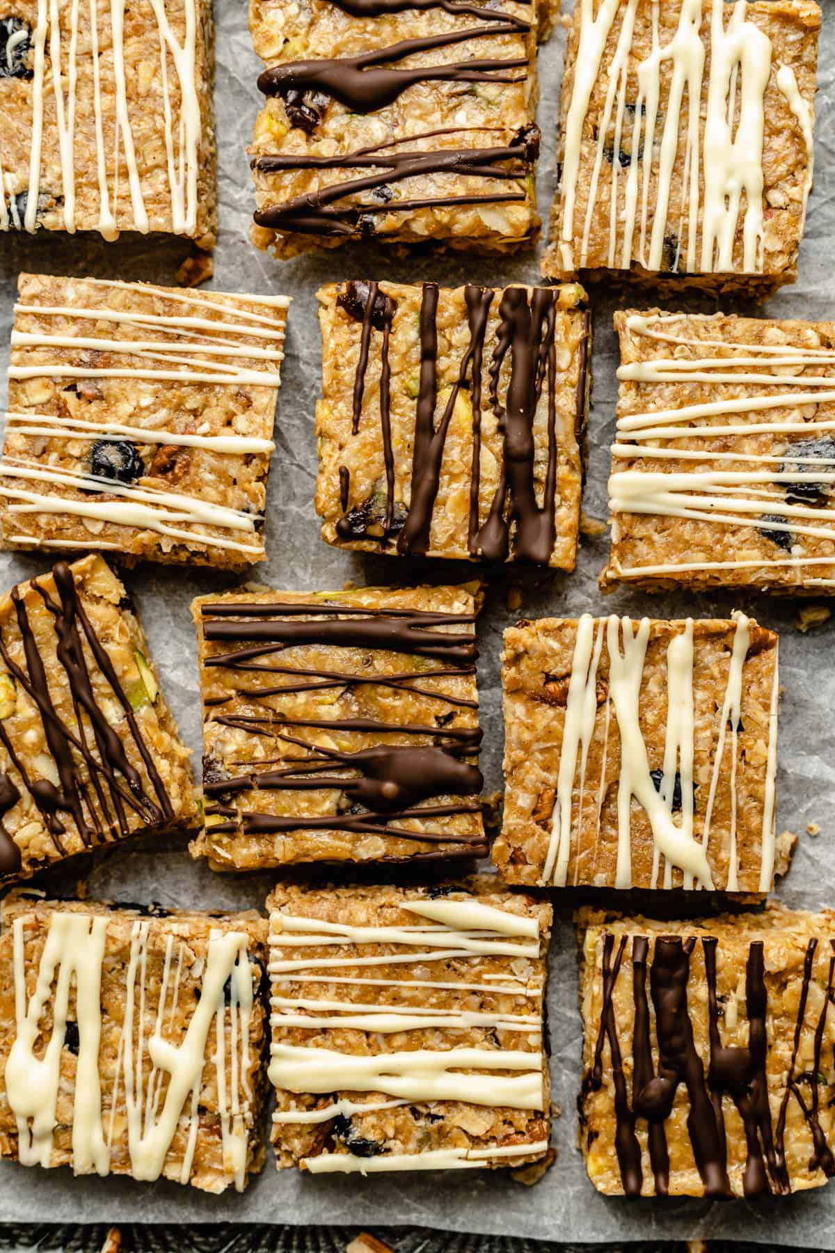 An array of no bake granola bars drizzled with white and dark chocolate.