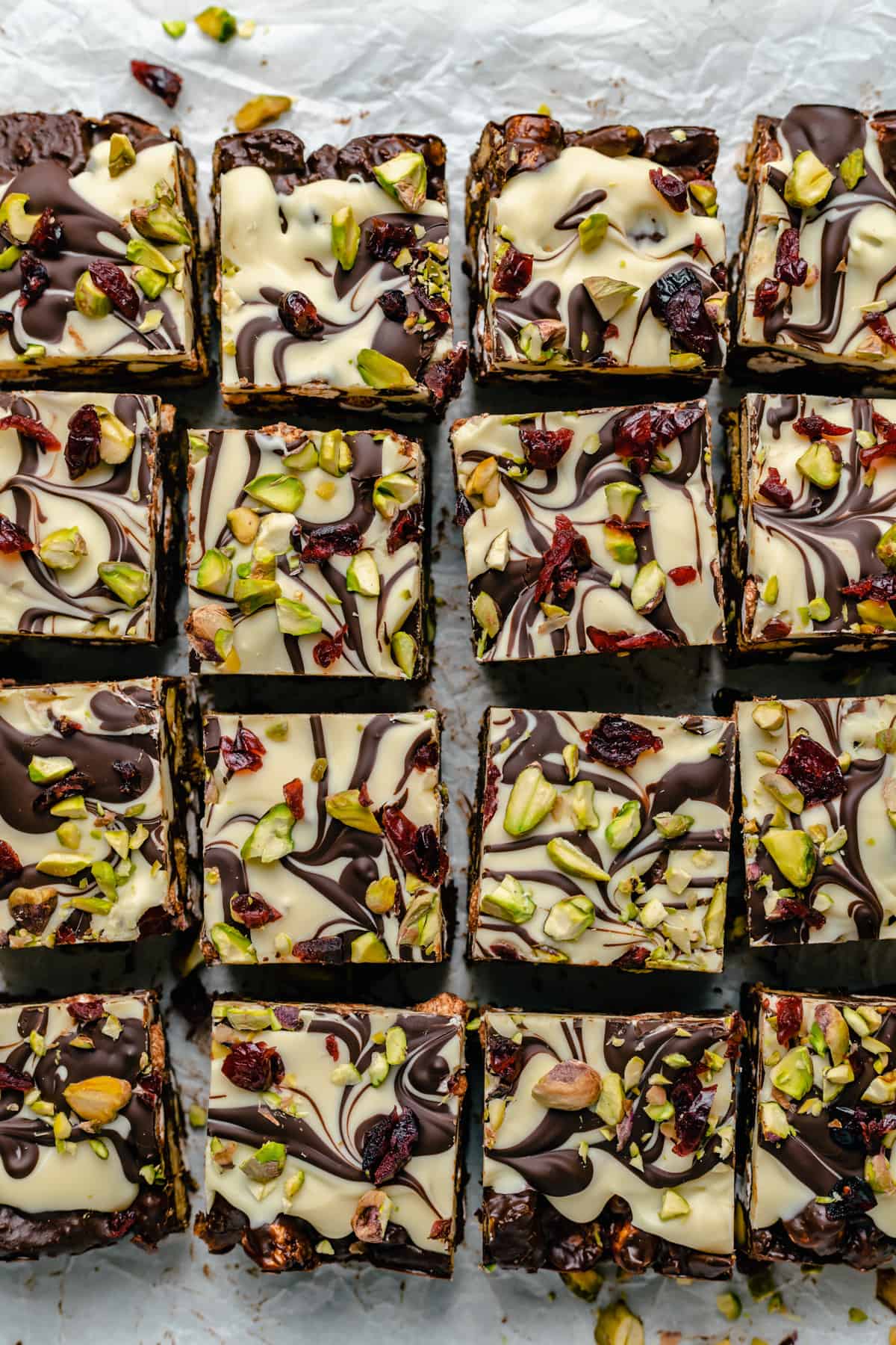 overhead image of christmas rocky road topped with dried cranberries and pistachios and chopped into squares.
